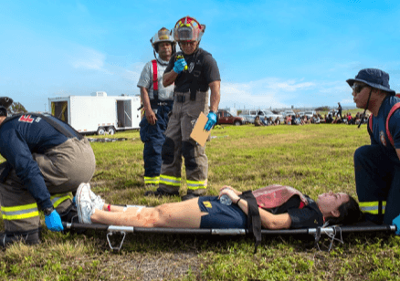 Emergency responders assisting an injured person on a stretcher