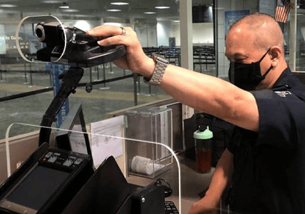 Security officer adjusting a camera at an airport checkpoint