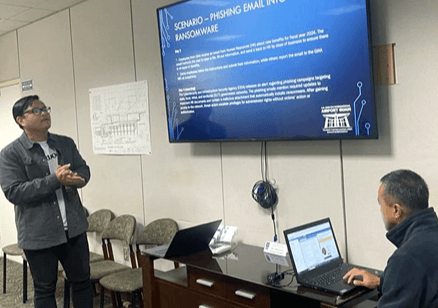 Presenter discussing a cybersecurity scenario with an attendee