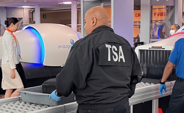 TSA officer inspecting luggage at an airport checkpoint