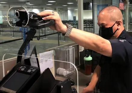Security officer adjusting a camera at an airport checkpoint