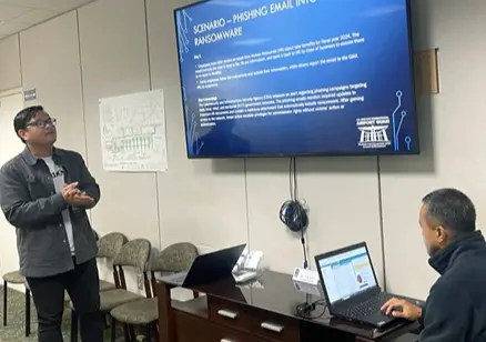 Presenter discussing a cybersecurity scenario with an attendee